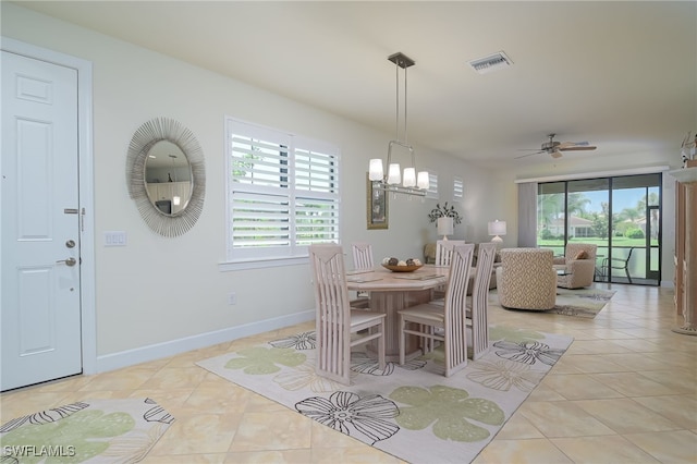 dining space with light tile patterned floors and ceiling fan with notable chandelier