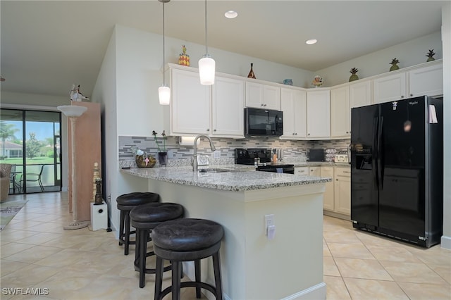 kitchen with kitchen peninsula, white cabinetry, black appliances, and decorative light fixtures