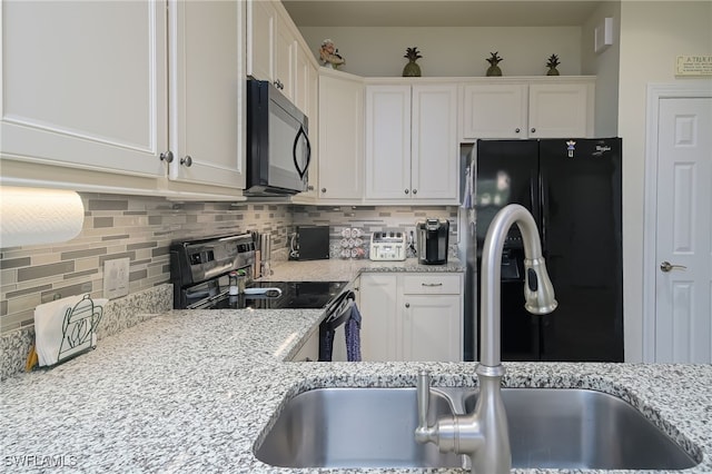 kitchen featuring white cabinets, tasteful backsplash, and black appliances