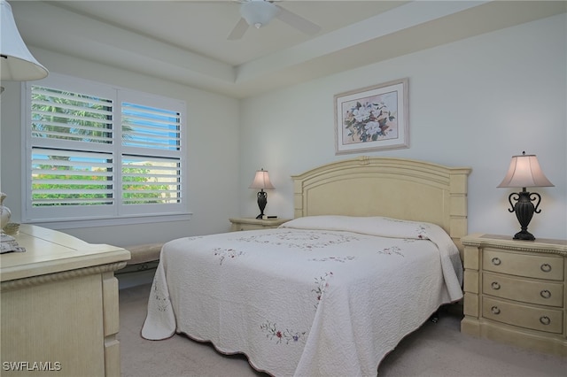 bedroom featuring a tray ceiling, ceiling fan, and light colored carpet