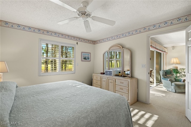 carpeted bedroom featuring ceiling fan and a textured ceiling