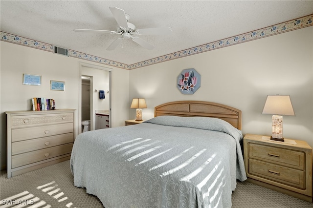 carpeted bedroom featuring ceiling fan, a textured ceiling, and connected bathroom