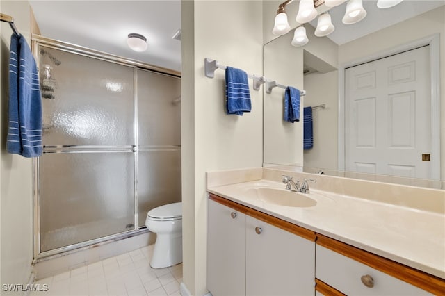 bathroom featuring vanity, a shower with shower door, and toilet