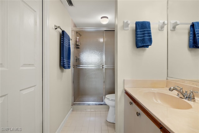 bathroom featuring tile patterned floors, vanity, toilet, and a shower with door