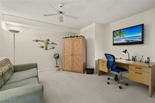 office featuring light carpet, ceiling fan, and a textured ceiling