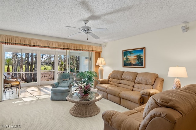 living room featuring ceiling fan, carpet floors, and a textured ceiling