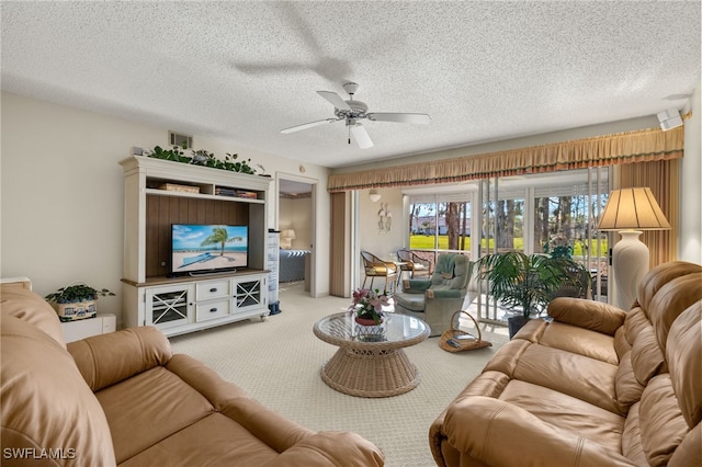 living room with ceiling fan, light carpet, and a textured ceiling