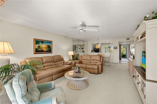 living room with a textured ceiling, ceiling fan, and light carpet