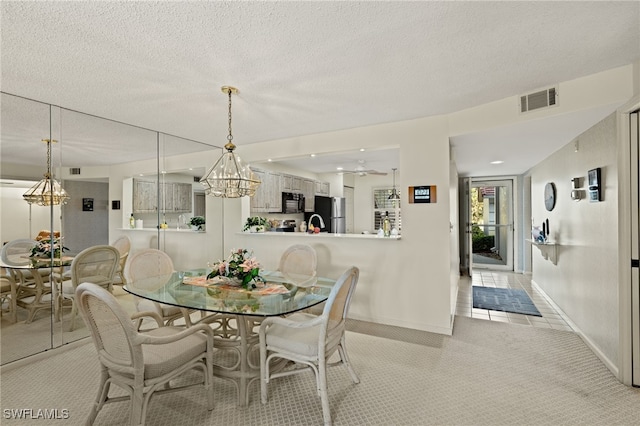 dining room with light carpet, a textured ceiling, and ceiling fan with notable chandelier