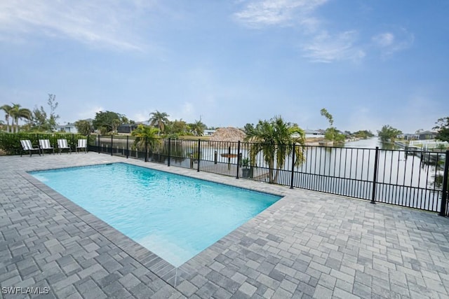 view of pool with a patio and a water view