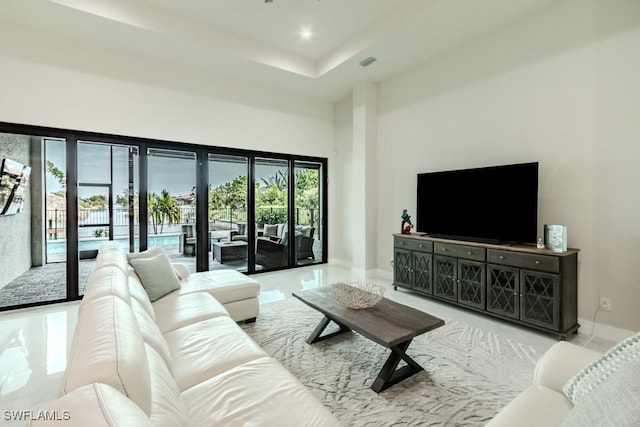 living area with baseboards, a high ceiling, visible vents, and recessed lighting