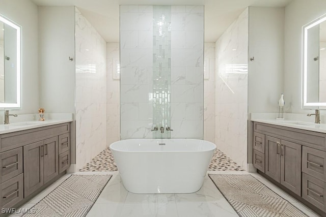 full bath with a soaking tub, two vanities, and a sink