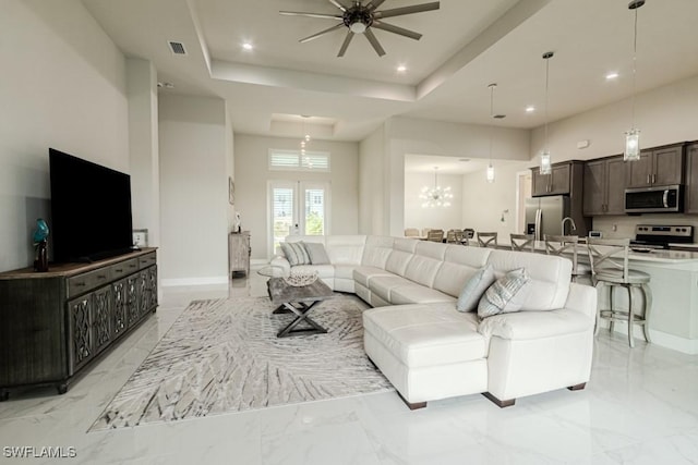 living area with recessed lighting, marble finish floor, visible vents, and a raised ceiling