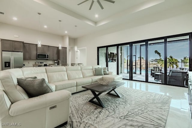 living area featuring visible vents, ceiling fan, marble finish floor, a high ceiling, and recessed lighting