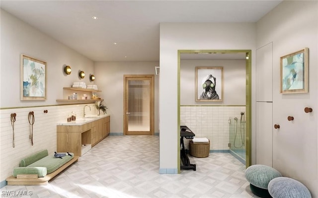 full bath with a shower stall, vanity, tile walls, and tile patterned floors