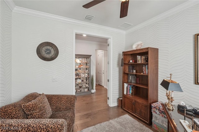 living room featuring hardwood / wood-style flooring, ornamental molding, and ceiling fan