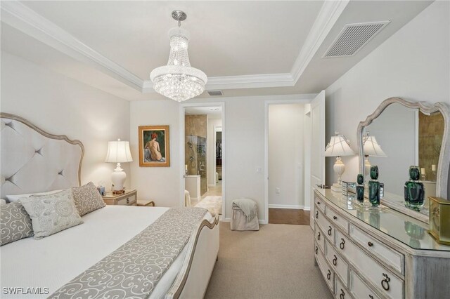 carpeted bedroom with ornamental molding, a tray ceiling, and a chandelier