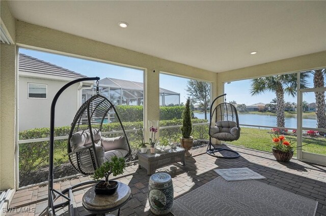 sunroom featuring a water view