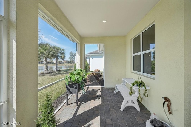 sunroom featuring a water view