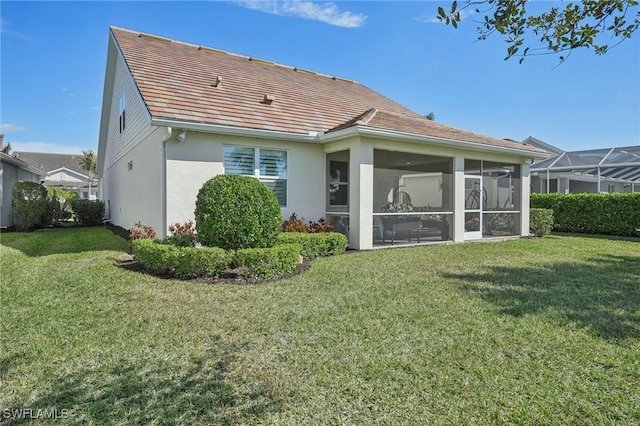 rear view of property with a sunroom and a lawn