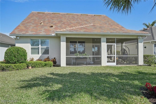 rear view of property with a lawn and a sunroom