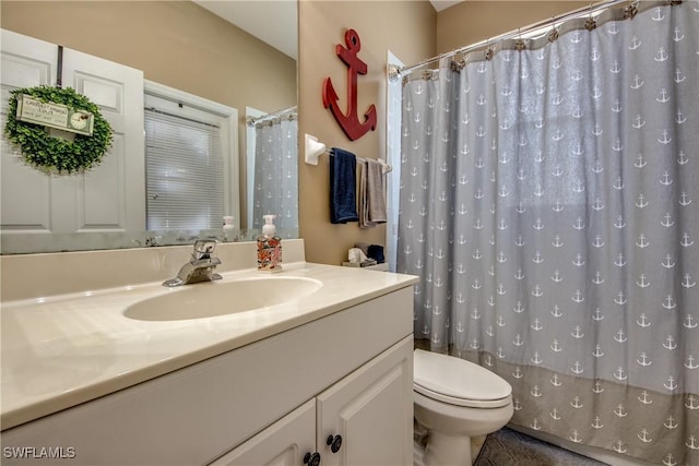 bathroom featuring walk in shower, vanity, and toilet