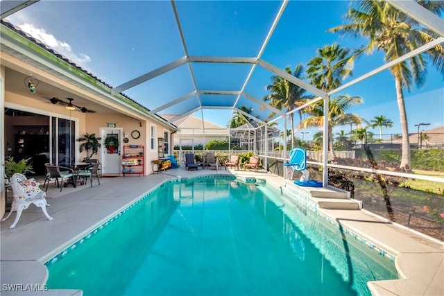 view of pool with glass enclosure and a patio