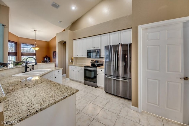 kitchen with appliances with stainless steel finishes, light stone counters, sink, white cabinetry, and hanging light fixtures