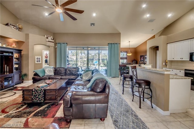 living room with ceiling fan, light tile patterned floors, and high vaulted ceiling