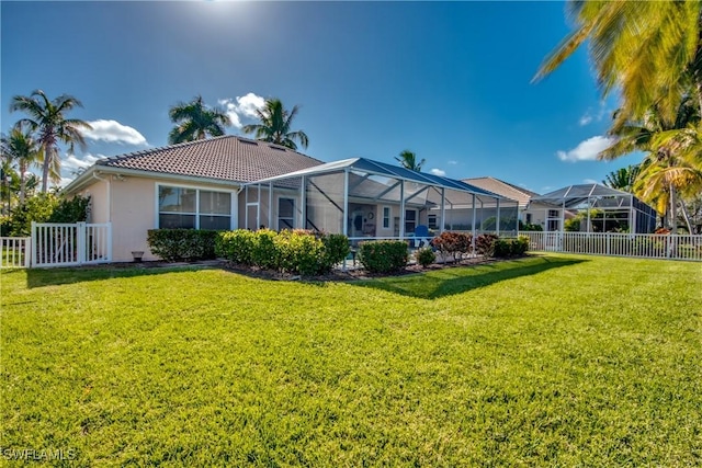 back of property featuring a lanai and a yard