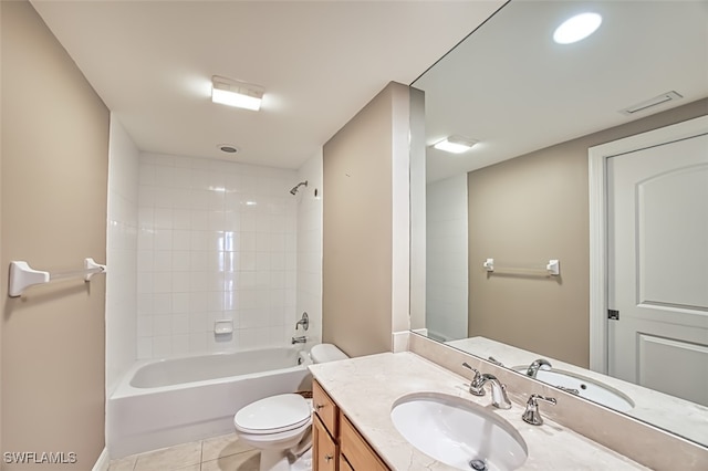bathroom featuring vanity, tile patterned flooring, washtub / shower combination, and toilet