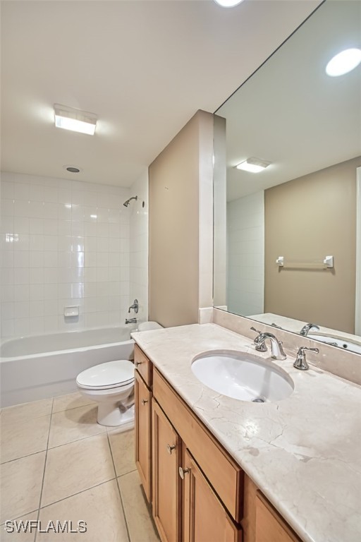 full bathroom featuring toilet, vanity, tile patterned floors, and tiled shower / bath