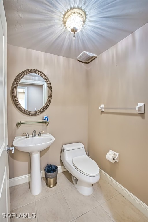 bathroom featuring tile patterned flooring, toilet, and sink