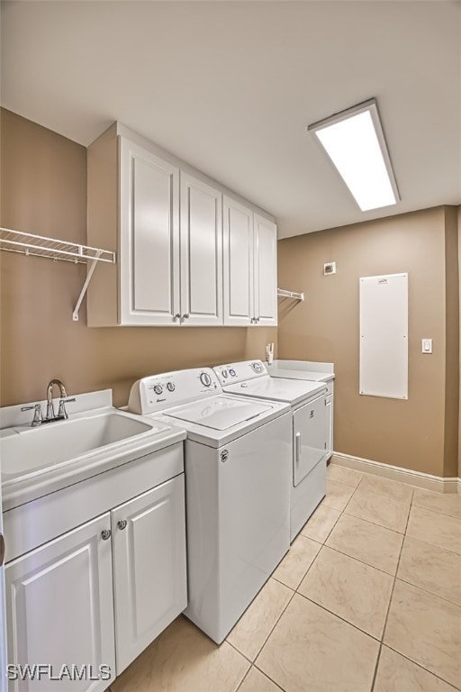 laundry room featuring cabinets, washing machine and dryer, sink, and light tile patterned flooring