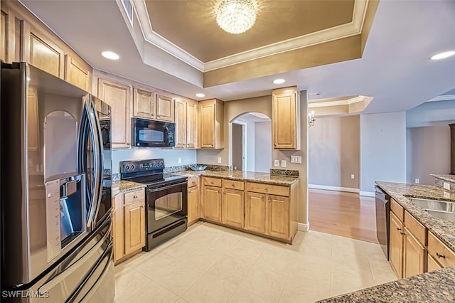 kitchen with crown molding, light brown cabinets, a raised ceiling, arched walkways, and black appliances