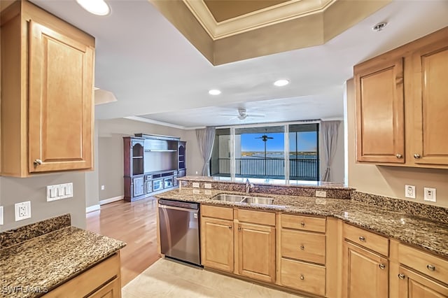 kitchen featuring dark stone counters, stainless steel dishwasher, ornamental molding, and sink