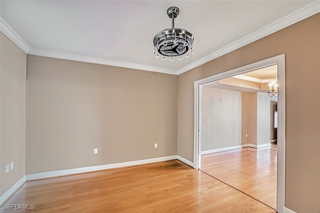 spare room featuring a chandelier, wood-type flooring, and ornamental molding