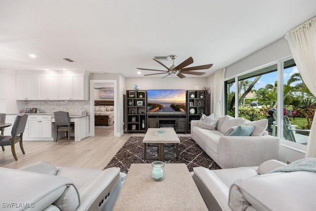 living room with ceiling fan and light hardwood / wood-style floors