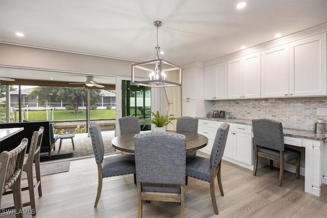 dining room with ceiling fan with notable chandelier, plenty of natural light, and light wood-type flooring