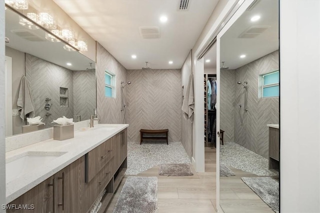 bathroom with a shower, a healthy amount of sunlight, and vanity