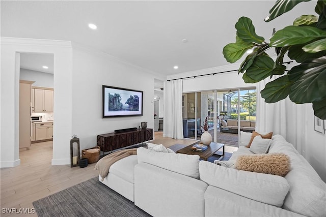 living room with light wood-type flooring and ornamental molding