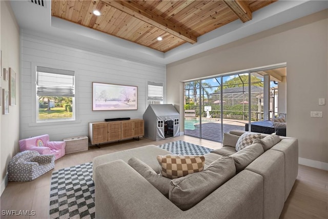 living room with beamed ceiling, wooden ceiling, and light hardwood / wood-style flooring