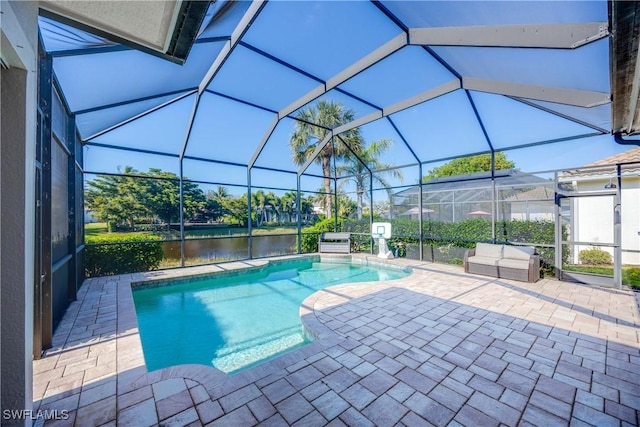 view of pool featuring a water view, a lanai, and a patio area