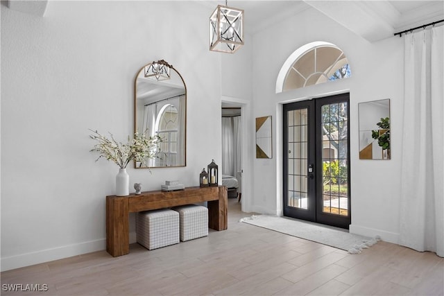 foyer entrance featuring french doors, light hardwood / wood-style floors, and ornamental molding