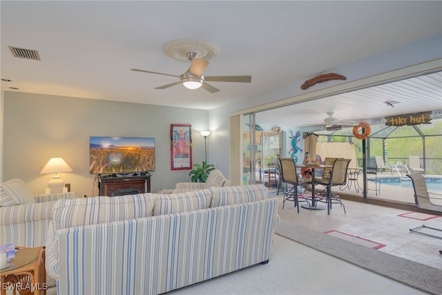 living room featuring ceiling fan and a wealth of natural light