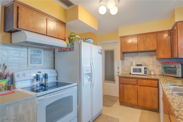 kitchen with white appliances, tasteful backsplash, and sink