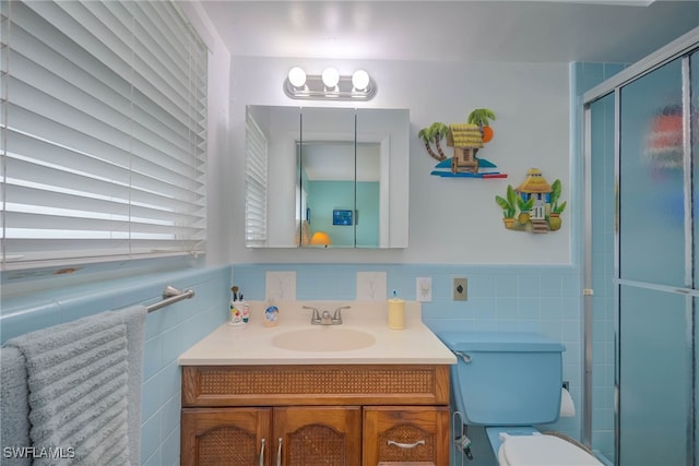 bathroom with tile walls, a shower with shower door, vanity, and toilet