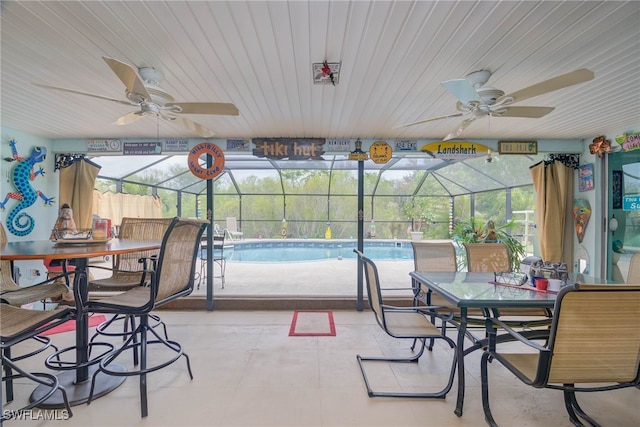 sunroom featuring a healthy amount of sunlight, a pool, and ceiling fan