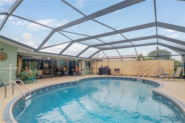 view of swimming pool with a patio area and glass enclosure