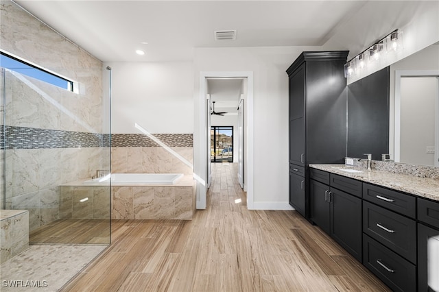 bathroom with ceiling fan, vanity, and shower with separate bathtub